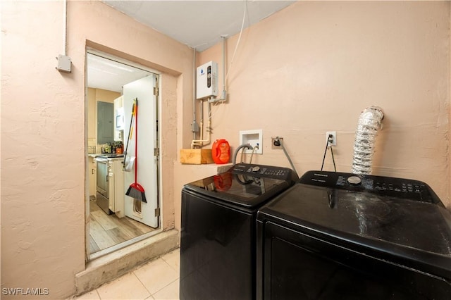 11831 Iona Rd, Fort Myers, FL 33908 - laundry area with separate washer and dryer, light tile patterned floors, and a textured wall