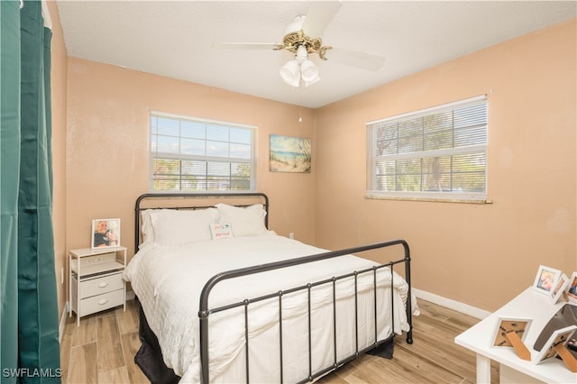 bedroom featuring a textured ceiling, light wood-type flooring, and ceiling fan