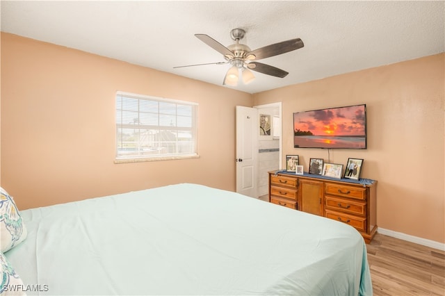 bedroom with light hardwood / wood-style floors, a textured ceiling, and ceiling fan