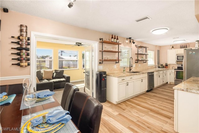 11831 Iona Rd, Fort Myers, FL 33908 - kitchen featuring a sink, appliances with stainless steel finishes, light stone countertops, ceiling fan, and white cabinets