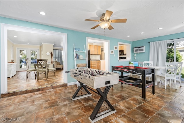 rec room with french doors, ceiling fan, a wealth of natural light, and a wall unit AC