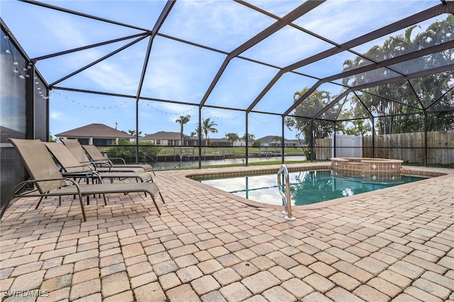 view of swimming pool featuring a patio, a storage shed, a water view, and glass enclosure