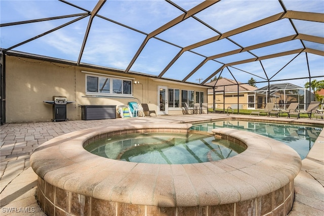 view of swimming pool featuring an in ground hot tub, area for grilling, a patio area, and a lanai