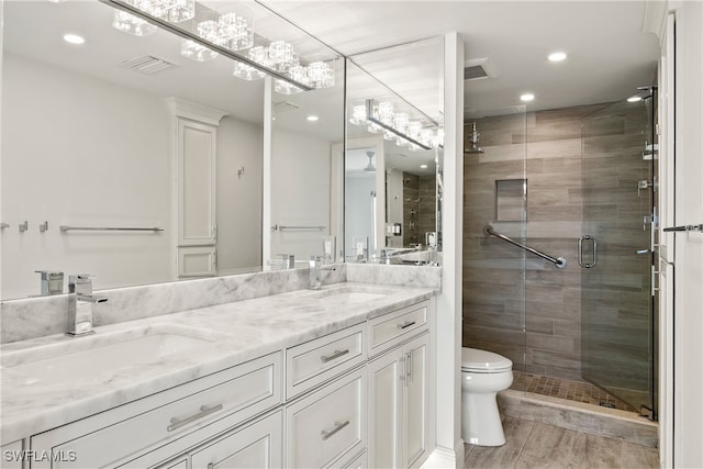 bathroom featuring toilet, an enclosed shower, and vanity