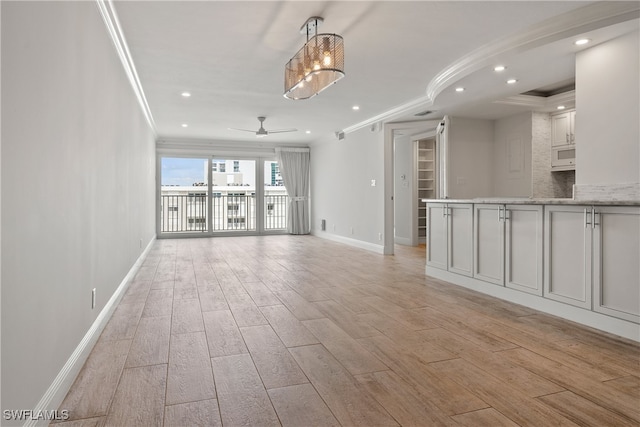 unfurnished living room featuring ceiling fan, light wood-type flooring, and crown molding