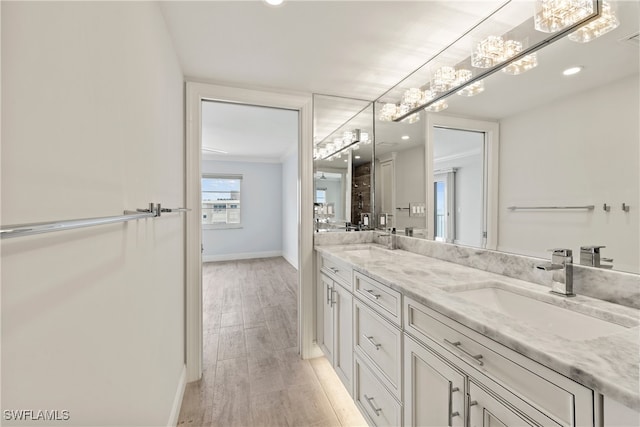 bathroom featuring ornamental molding, hardwood / wood-style floors, and vanity