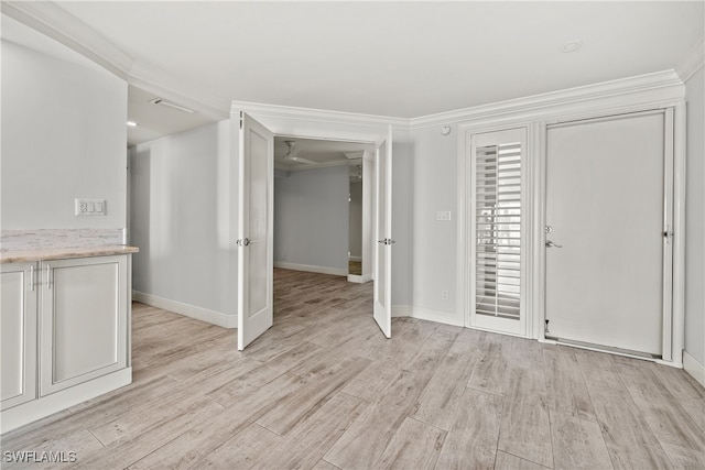 foyer entrance featuring light hardwood / wood-style floors and ornamental molding