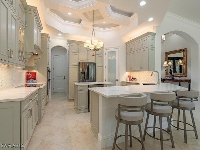 kitchen with pendant lighting, kitchen peninsula, sink, gray cabinetry, and stainless steel fridge with ice dispenser