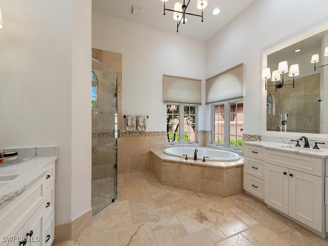 bathroom with vanity, shower with separate bathtub, and an inviting chandelier