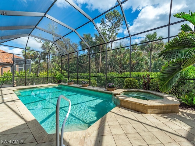 view of swimming pool featuring an in ground hot tub, glass enclosure, and a patio