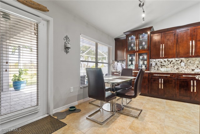 dining space featuring lofted ceiling and light tile patterned floors