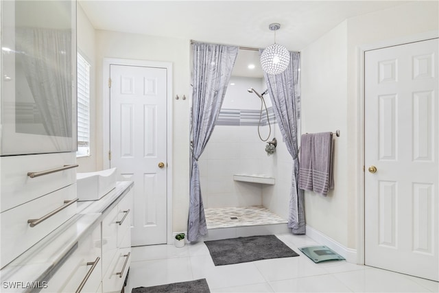 bathroom with a shower with curtain, vanity, and tile patterned floors