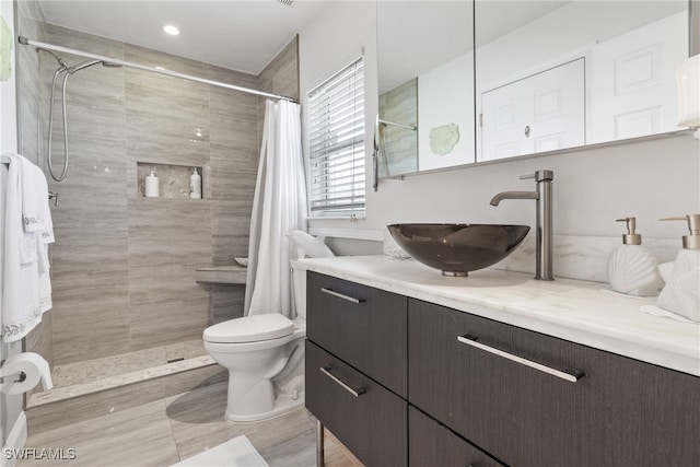 bathroom featuring a shower with curtain, hardwood / wood-style flooring, vanity, and toilet