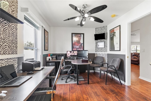 home office with dark hardwood / wood-style flooring and ceiling fan