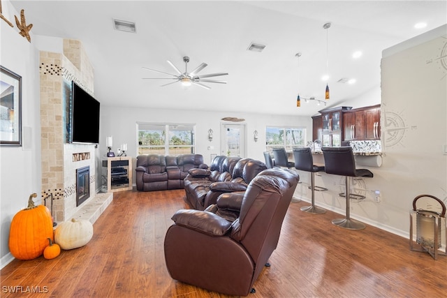 living room featuring a large fireplace, dark hardwood / wood-style floors, ceiling fan, and vaulted ceiling