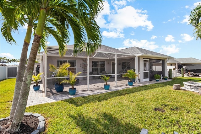 back of house featuring glass enclosure, a lawn, a sunroom, and a patio area