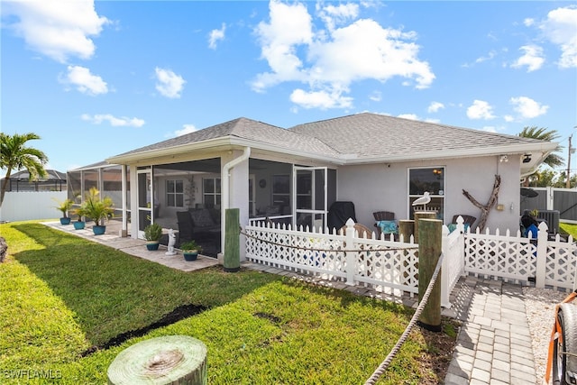 rear view of property with a sunroom and a yard