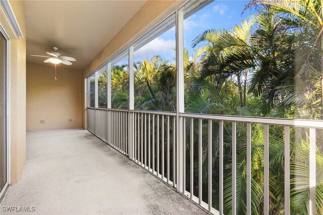 unfurnished sunroom with ceiling fan