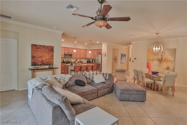 tiled living room featuring sink, crown molding, and ceiling fan with notable chandelier