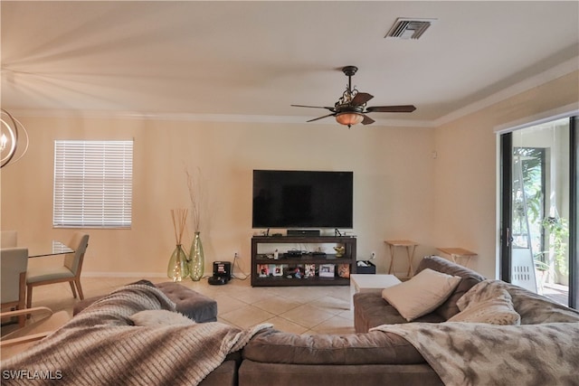 living room with crown molding, ceiling fan with notable chandelier, and light tile patterned floors