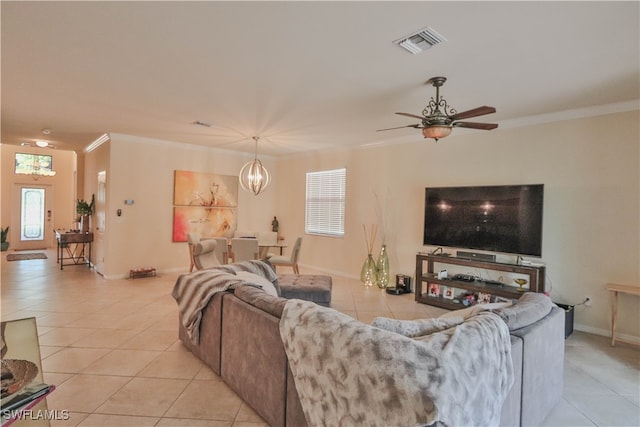 tiled living room with crown molding and ceiling fan with notable chandelier