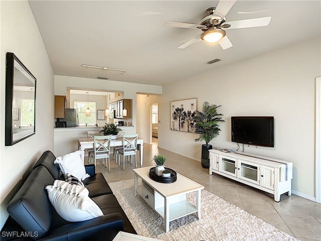 tiled living room with rail lighting and ceiling fan