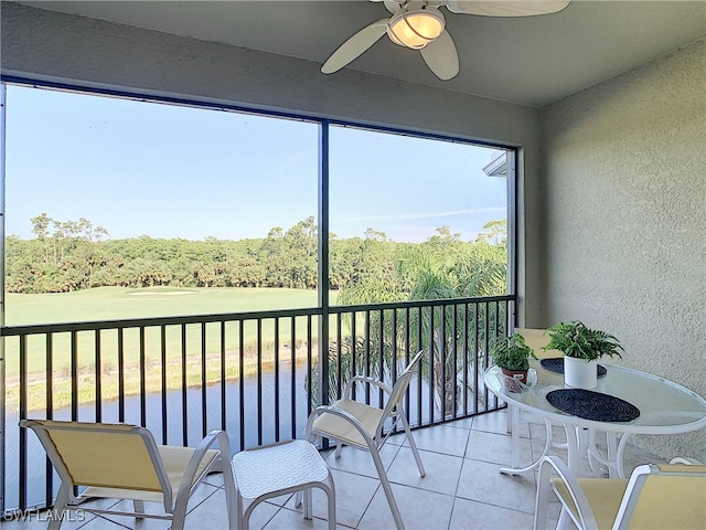 sunroom with a water view and ceiling fan