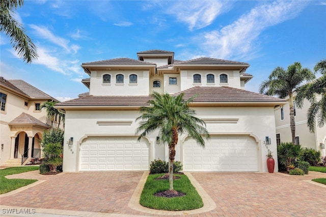 27588 River Reach Dr, Bonita Springs, FL 34134 - mediterranean / spanish-style home with decorative driveway, stucco siding, and a tile roof