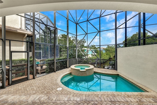 view of swimming pool with glass enclosure, a patio area, and an in ground hot tub