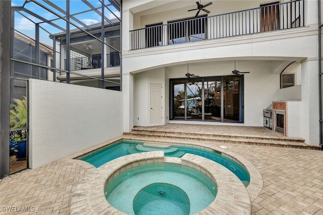 view of swimming pool with glass enclosure, a patio area, ceiling fan, and an in ground hot tub