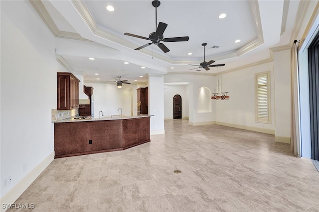 kitchen with kitchen peninsula, a raised ceiling, and crown molding