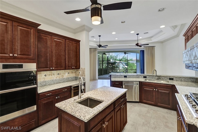 kitchen with an island with sink, kitchen peninsula, appliances with stainless steel finishes, and ornamental molding