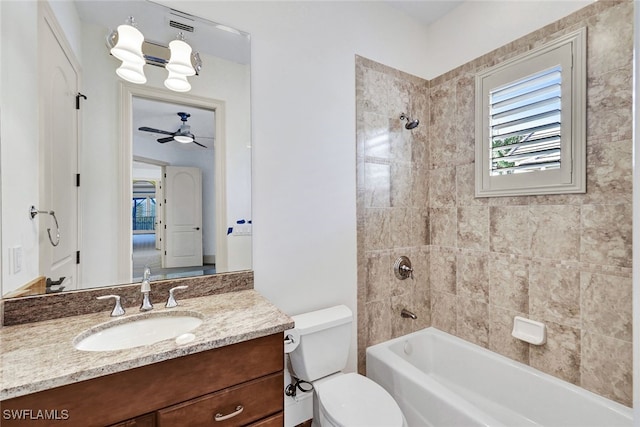 full bathroom featuring ceiling fan, vanity, toilet, and tiled shower / bath