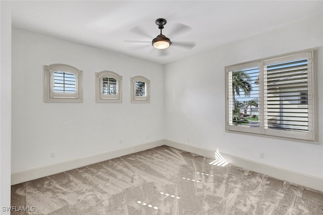 carpeted spare room featuring ceiling fan