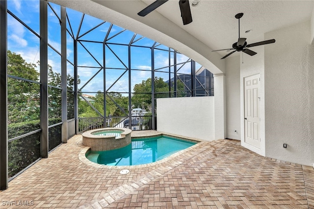 view of swimming pool with a lanai, ceiling fan, an in ground hot tub, and a patio area