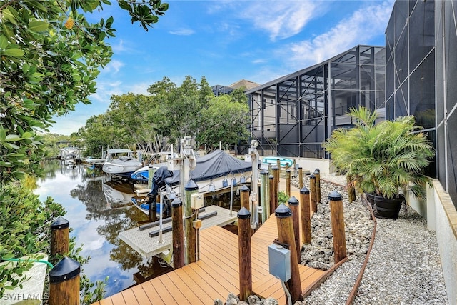 dock area with a lanai and a water view