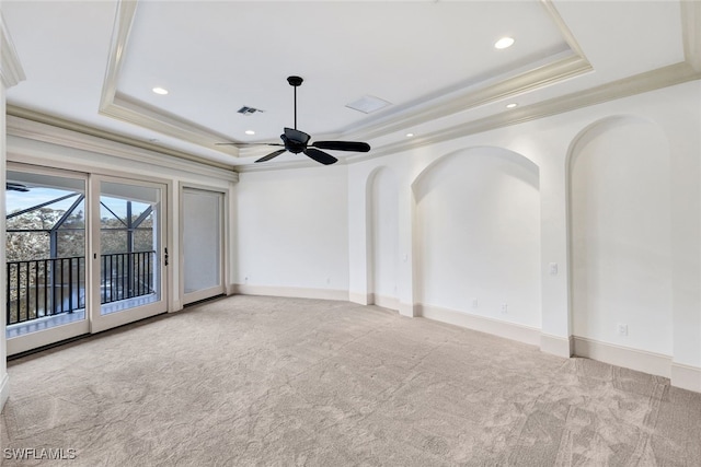 unfurnished room featuring ceiling fan, light carpet, a raised ceiling, and crown molding