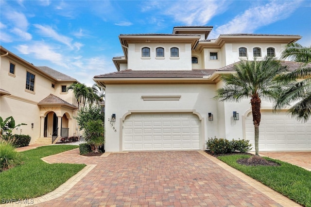 27588 River Reach Dr, Bonita Springs, FL 34134 - mediterranean / spanish-style home featuring stucco siding, decorative driveway, a garage, and a tile roof