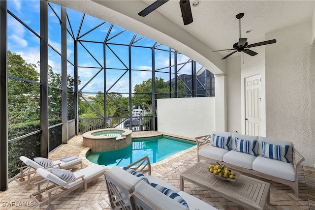 view of swimming pool with an in ground hot tub, outdoor lounge area, glass enclosure, ceiling fan, and a patio