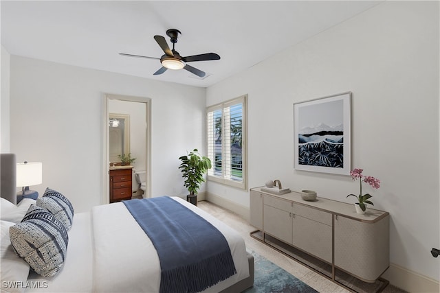 bedroom with ensuite bathroom, light carpet, and ceiling fan