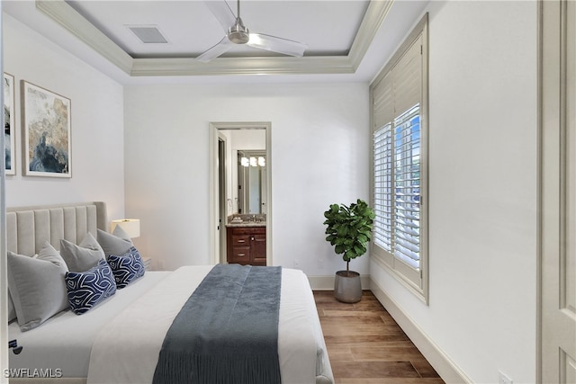 bedroom featuring hardwood / wood-style flooring, ceiling fan, ensuite bath, and ornamental molding