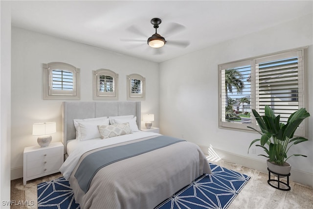 carpeted bedroom with multiple windows and ceiling fan