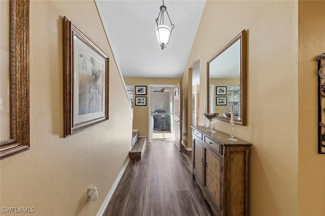 corridor featuring vaulted ceiling and dark hardwood / wood-style floors