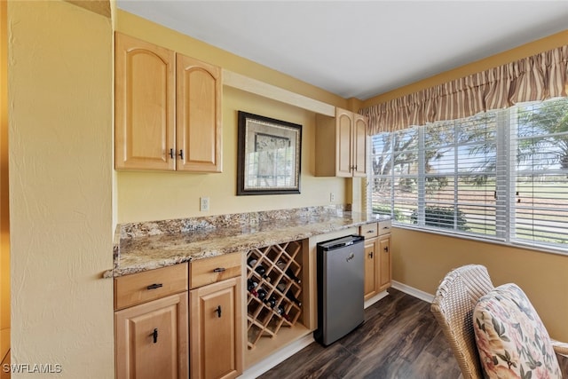 bar featuring light stone countertops, light brown cabinetry, dark wood-type flooring, and fridge