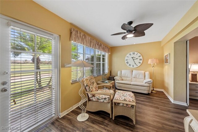 sitting room with dark hardwood / wood-style flooring, a wealth of natural light, and ceiling fan