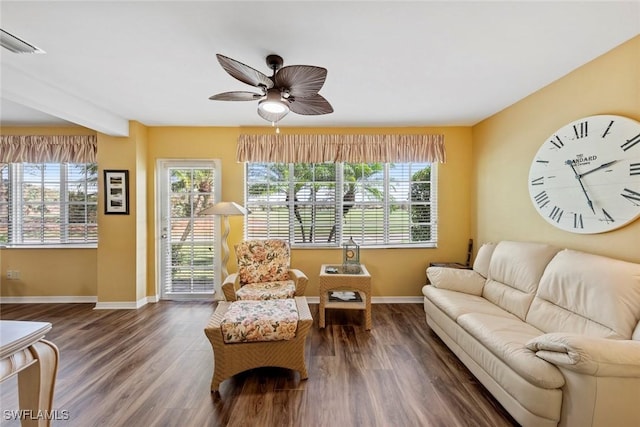 sitting room featuring beamed ceiling, ceiling fan, and dark wood-type flooring