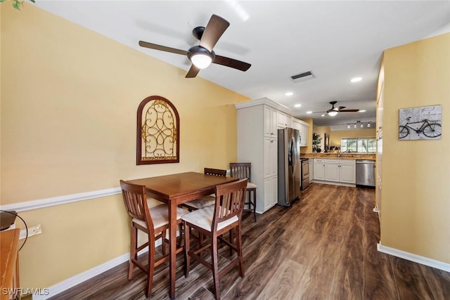 dining area with ceiling fan and dark hardwood / wood-style floors