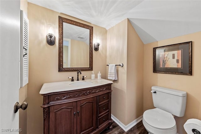 bathroom featuring lofted ceiling, vanity, toilet, and hardwood / wood-style floors