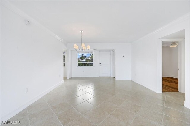 tiled empty room featuring ceiling fan with notable chandelier and ornamental molding