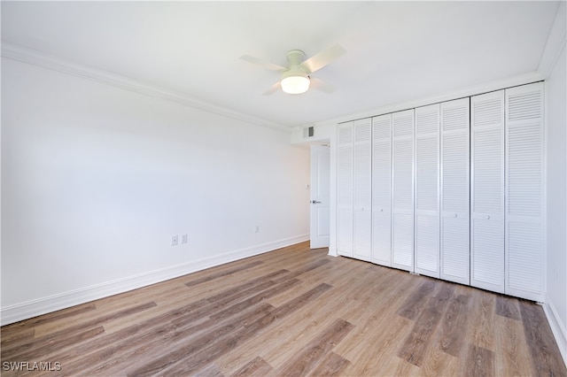 unfurnished bedroom with ceiling fan, a closet, ornamental molding, and light hardwood / wood-style flooring